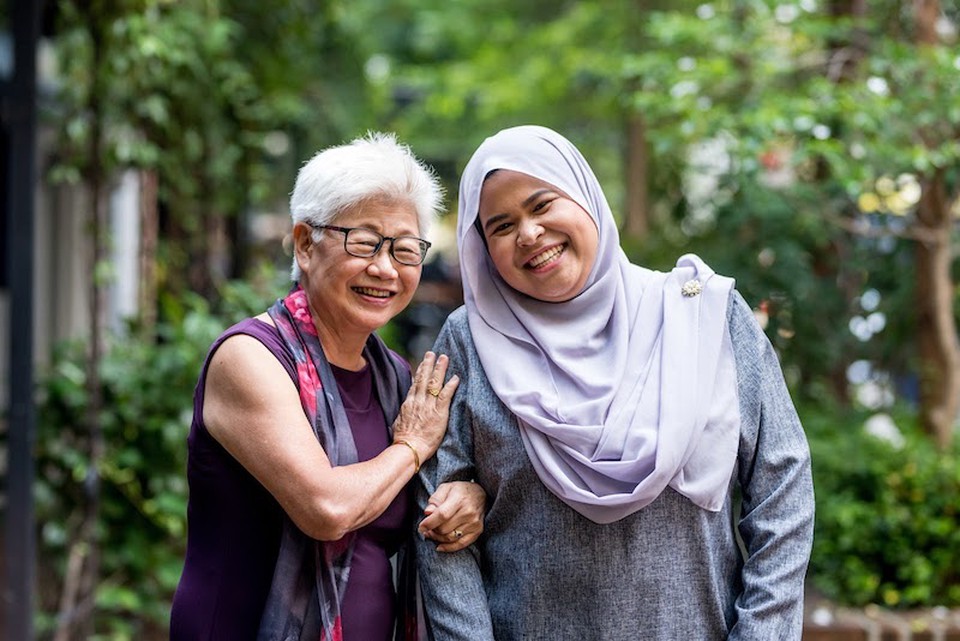 Two smiling women stand side by side.
