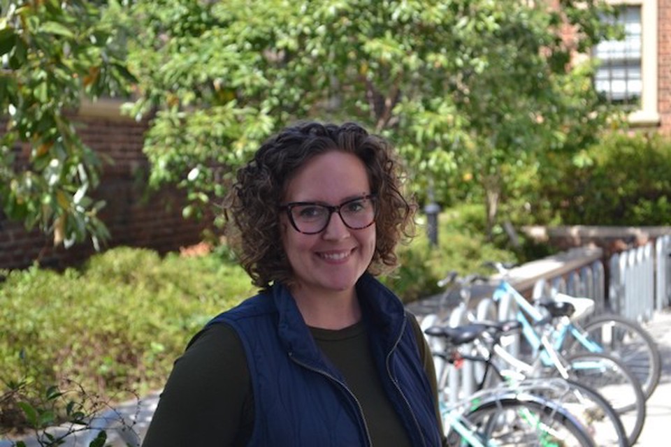 Kimberly Compton, an instructor and doctoral candidate at the VCU School of Social Work, stands outside smiling.