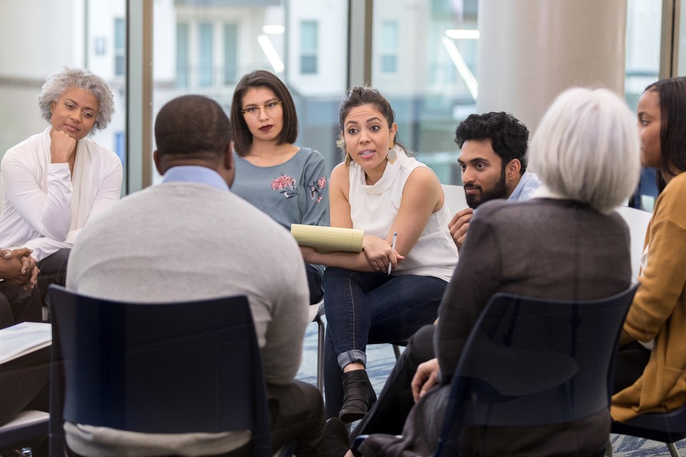 People sit in circle during group therapy session.