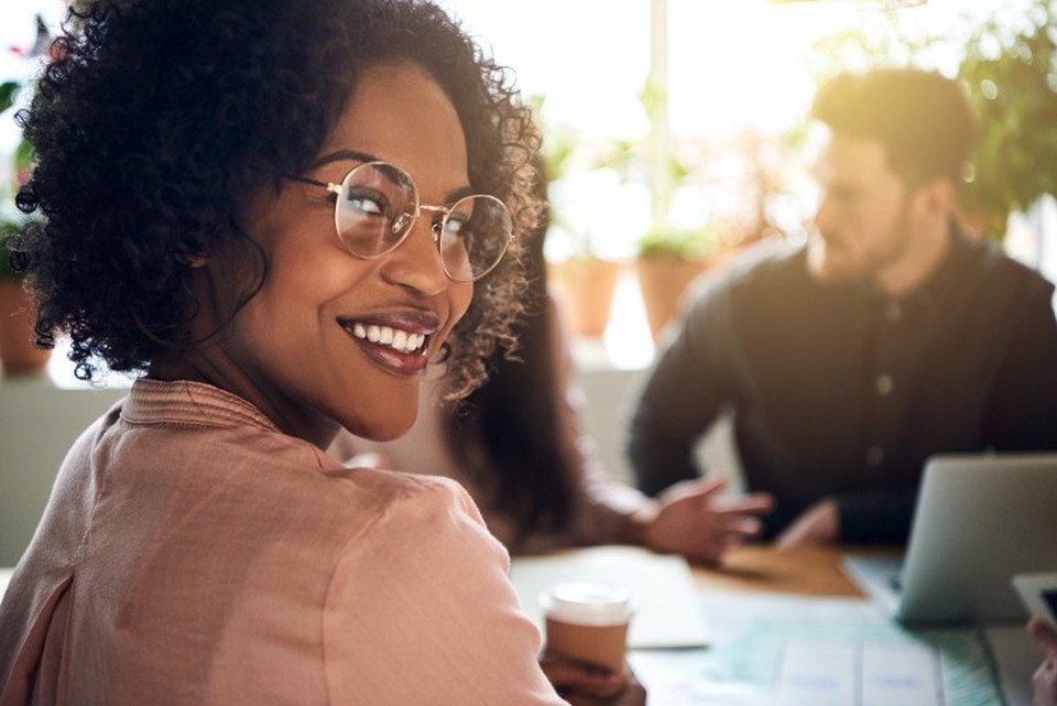A smiling social worker looks over their shoulder.
