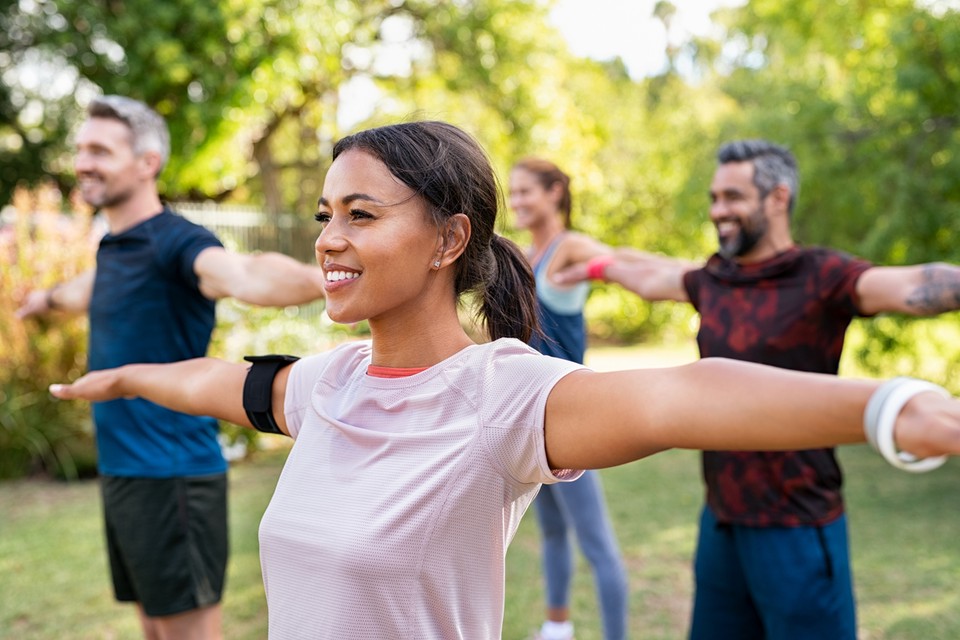 A social worker practicing self-care exercises in a park.