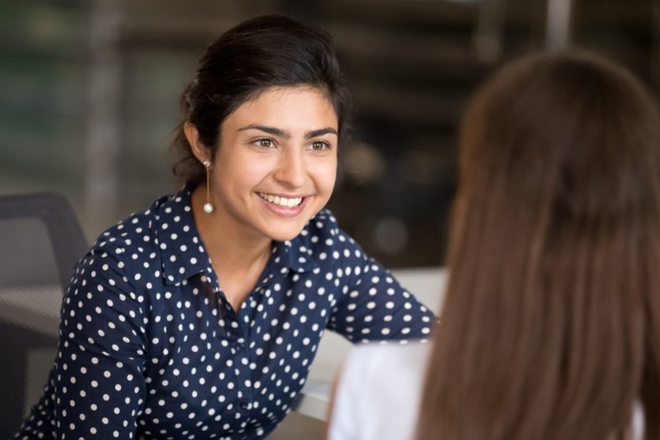 A smiling social worker listens to a client.