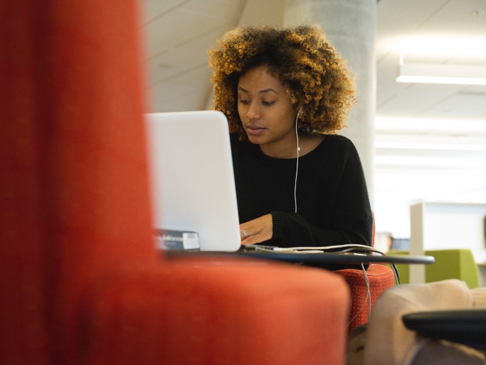 A msw degree student sits at a table and works on her laptop