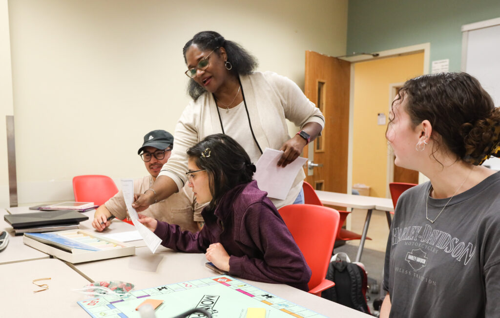 Dr. Qasarah Bey Spencer works with students in a classroom.