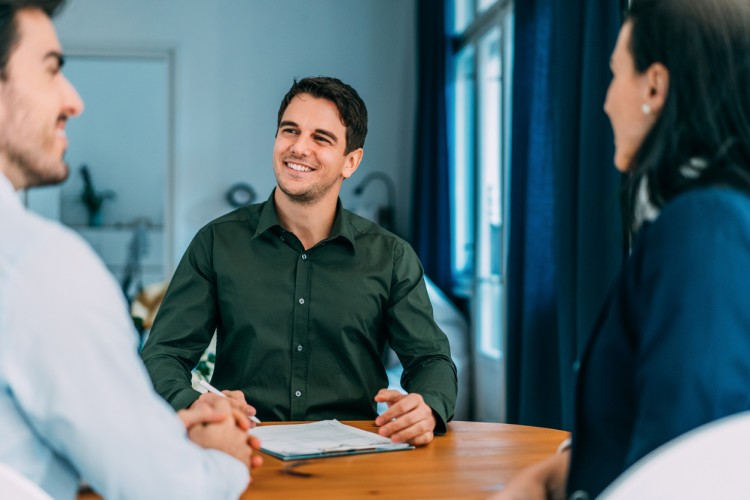 A social worker smiling and meeting with clients.