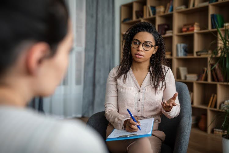 A social worker talks with a client in a private office.